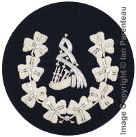 Embroidered silver wire on navy blue cloth wreathed bagpipes Pipe Major insignia badge